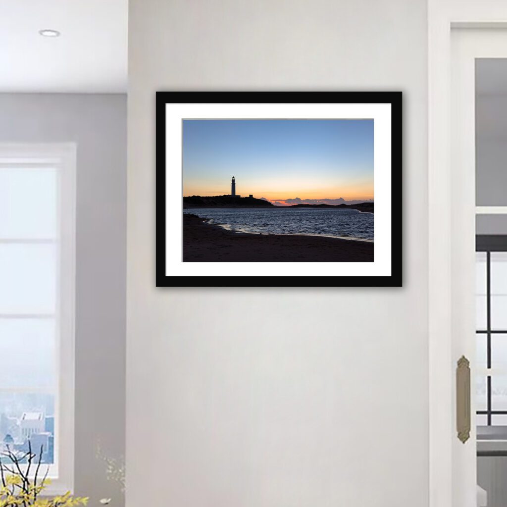 A captivating depiction of Cape Trafalgar’s lighthouse, elegantly silhouetted against the canvas of a sunset sky,