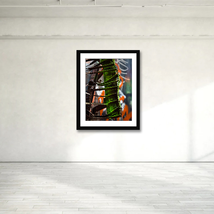 This striking print captures an unexpected fusion of art and derailment, where twisted metal meets vibrant graffiti, forming a unique green caterpillar.