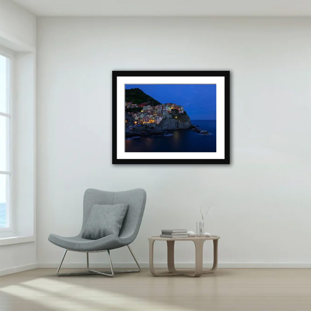 This image encapsulates a serene twilight moment in Manarola, where the first hints of evening lights begin to sprinkle the town, creating a magical ambiance.
