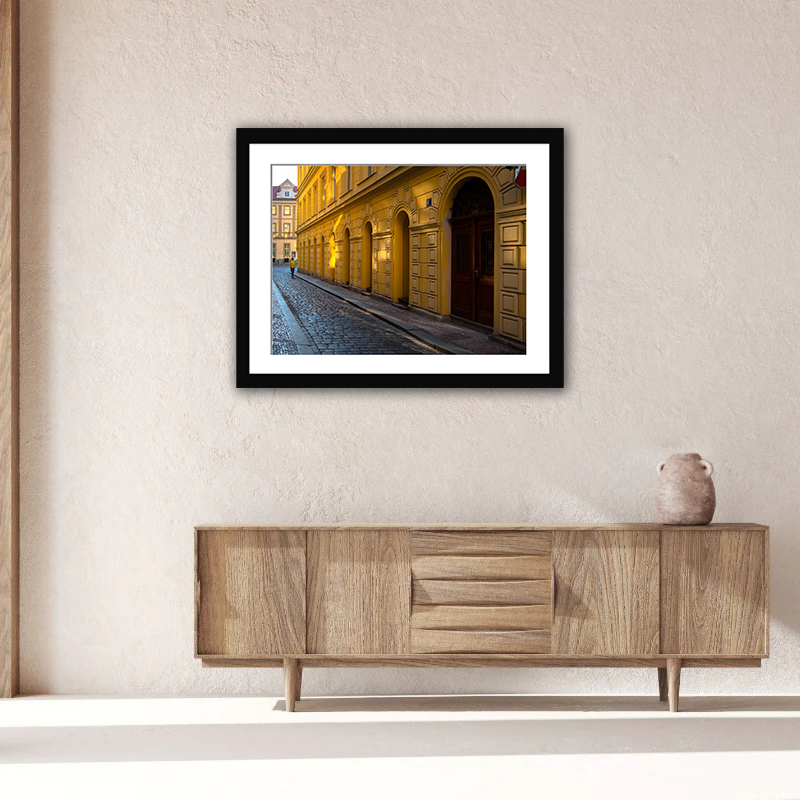 This A vivid depiction of Prague at dawn, capturing the golden light that graces the facade of a classic Czech building. encapsulates the serene aura of Charles Bridge, Prague, during the early morning, showcased in beautiful black and white tones.