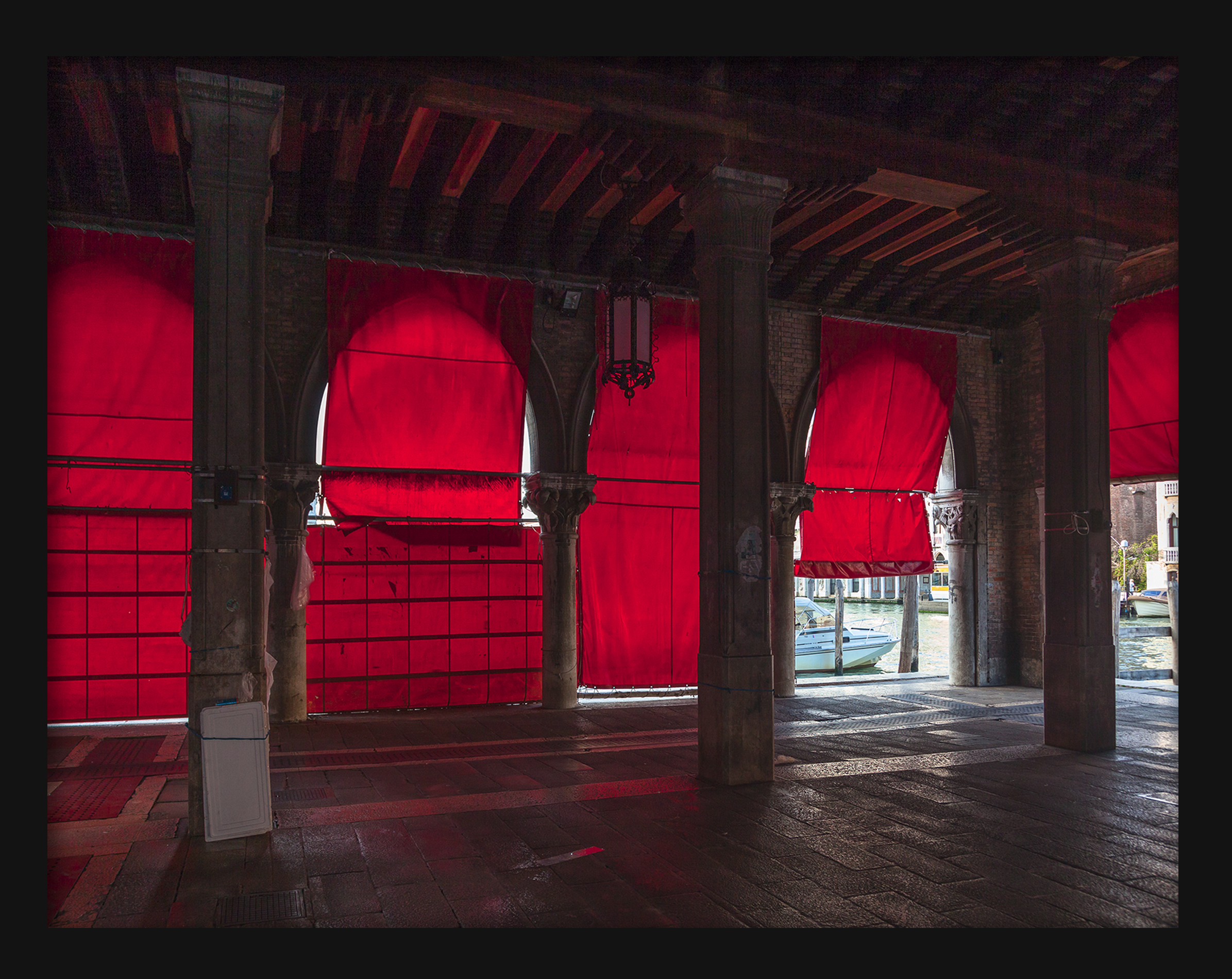 Immerse yourself in the calming yet vibrant ambiance of Venice, beautifully captured through the red hues of a picturesque warehouse that embodies tranquility and style.
