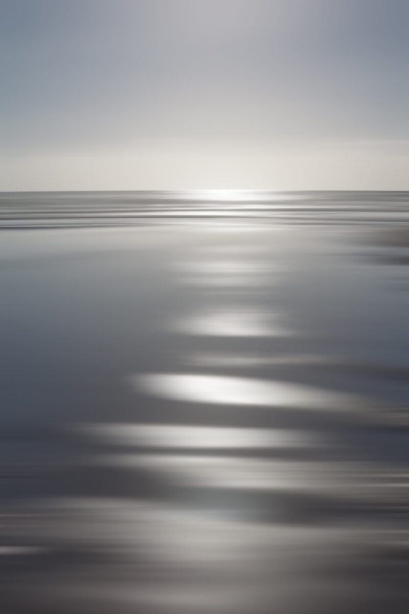 Dive into the mesmerizing canvas where the sun paints intense silver patterns across the Oregon sands and distant waves.