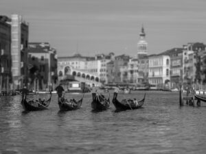 Experience the poetry of Venice through this exquisite black and white representation, showcasing a quartet of gondolas gracefully navigating the Grand Canal.