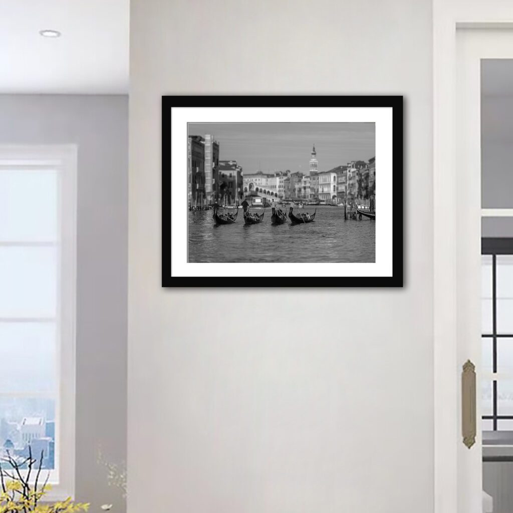 Experience the poetry of Venice through this exquisite black and white representation, showcasing a quartet of gondolas gracefully navigating the Grand Canal.