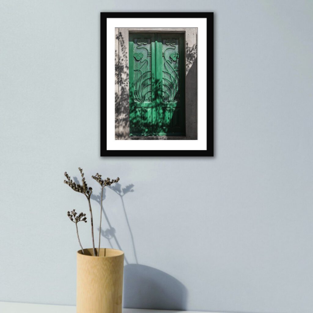 Emerald green door in Chora, Mykonos with intricate patterns.