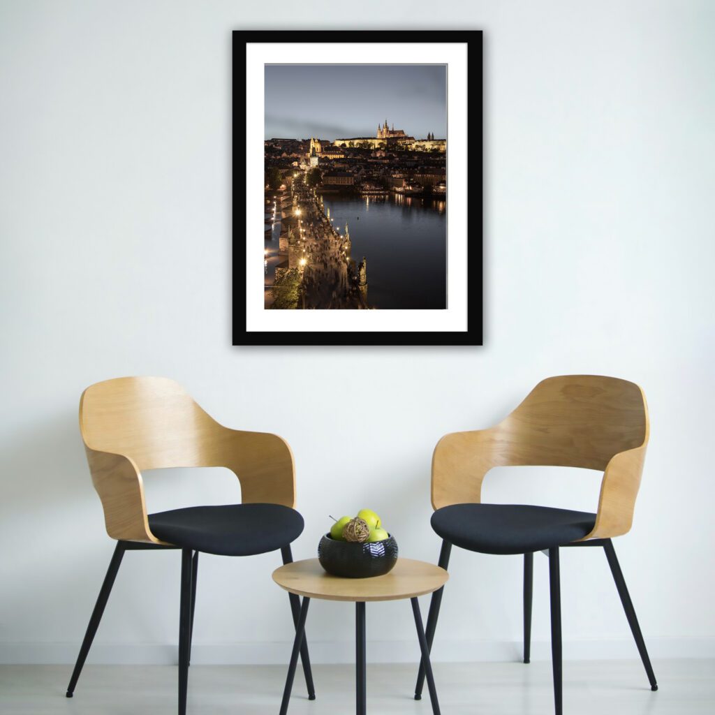 Prague cityscape during twilight with illuminated landmarks and reflections on the Vltava River.