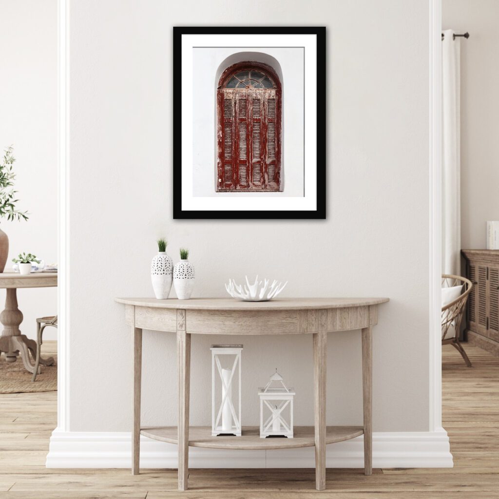 Aged red door with arched window in Mykonos.