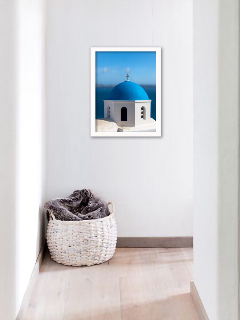 Blue domed church in Santorini overlooking the serene blue waters of the caldera.