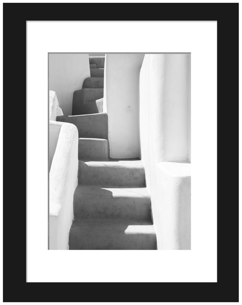 Black and white photo of an ancient staircase with shadows in Santorini, Greece.