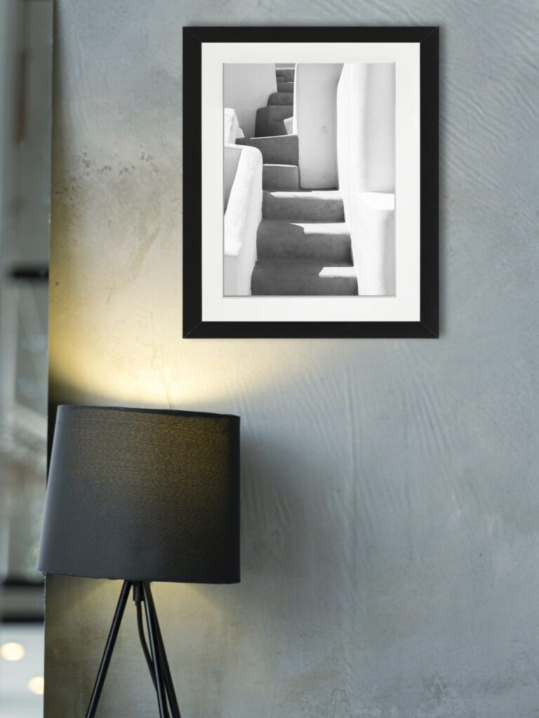 Black and white photo of an ancient staircase with shadows in Santorini, Greece.