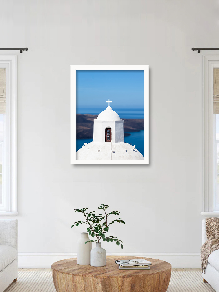 White-domed church in Santorini with a clear view of the blue caldera.